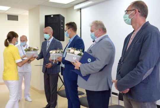 Lekarze wręczają kwiaty dyrektorowi szpitala