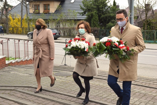 Przewodnicząca Rady Powiatu Bożena Wrona, poseł Agata Wojtyszek oraz starosta Piotr Babicki składają kwiaty przed Pomnikiem Niepodległości